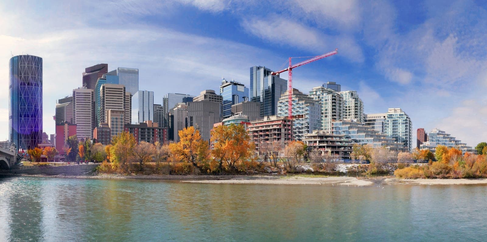 The Bow River winding past downtown Calgary's skyline on a clear day.